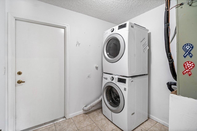 145 Waterway Rd, Royal Palm Beach, FL 33411 - laundry area featuring stacked washer and clothes dryer, light tile patterned floors, and a textured ceiling