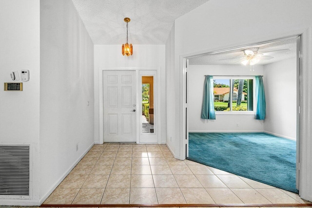 145 Waterway Rd, Royal Palm Beach, FL 33411 - entryway with a textured ceiling, light colored carpet, light tile patterned floors, and a ceiling fan
