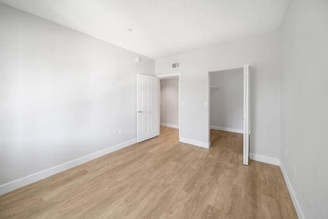 11765 W Atlantic Blvd Unit 1626, Coral Springs, FL 33071 - unfurnished bedroom with light wood-style flooring, a spacious closet, and a closet