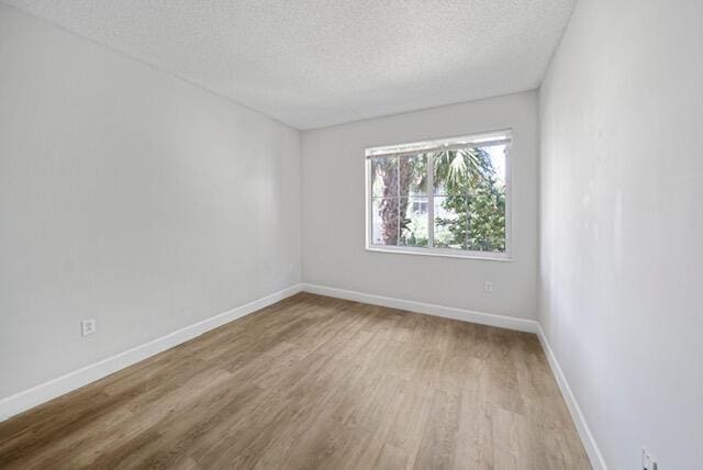 11765 W Atlantic Blvd Unit 1626, Coral Springs, FL 33071 - unfurnished room with a textured ceiling and wood finished floors