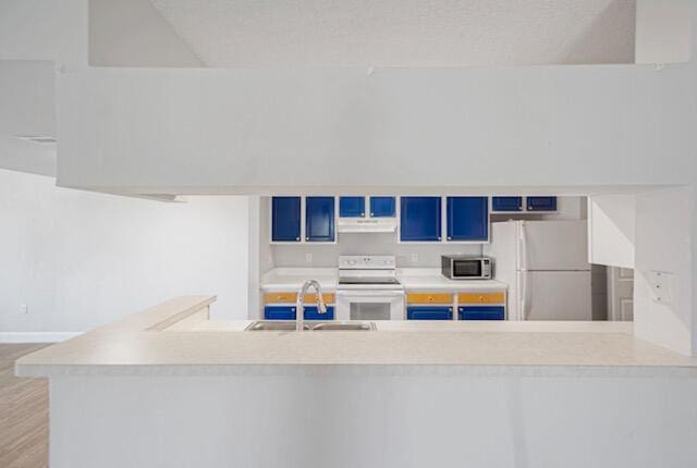 11765 W Atlantic Blvd Unit 1626, Coral Springs, FL 33071 - kitchen featuring white appliances, blue cabinetry, light countertops, under cabinet range hood, and wood finished floors