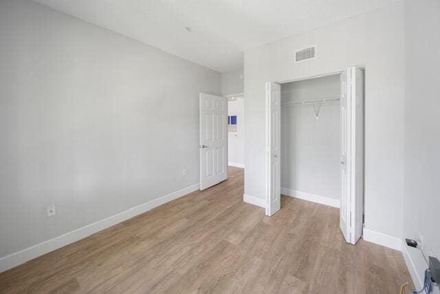 11765 W Atlantic Blvd Unit 1626, Coral Springs, FL 33071 - unfurnished bedroom featuring light wood finished floors and a closet