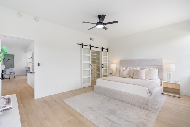 5189 Lake Catalina Dr Unit A, Boca Raton, FL 33496 - bedroom featuring a barn door, light wood-style flooring, and ceiling fan