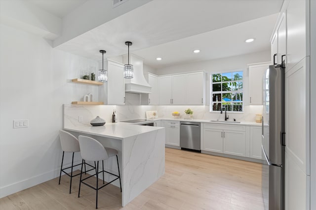 5189 Lake Catalina Dr Unit A, Boca Raton, FL 33496 - kitchen featuring appliances with stainless steel finishes, a peninsula, tasteful backsplash, custom range hood, and white cabinets