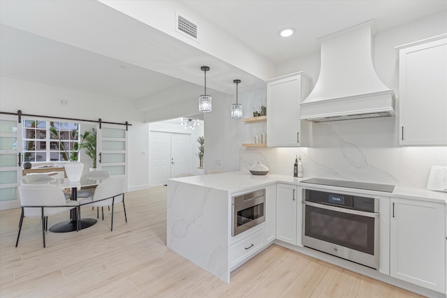 5189 Lake Catalina Dr Unit A, Boca Raton, FL 33496 - kitchen with appliances with stainless steel finishes, custom range hood, a barn door, a peninsula, and white cabinets