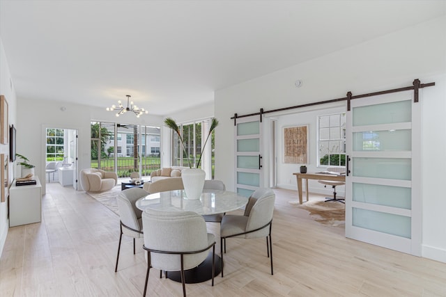5189 Lake Catalina Dr Unit A, Boca Raton, FL 33496 - dining room featuring a barn door, a chandelier, and light wood-style flooring