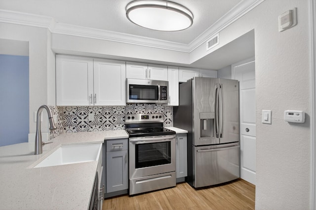 15155 Michelangelo Blvd Unit 103, Delray Beach, FL 33446 - kitchen with stainless steel appliances, crown molding, light wood finished floors, decorative backsplash, and white cabinets