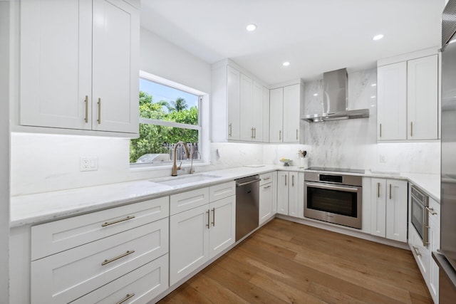 1116 SE 11th St, Fort Lauderdale, FL 33316 - kitchen with stainless steel appliances, wall chimney exhaust hood, decorative backsplash, white cabinetry, and light stone countertops
