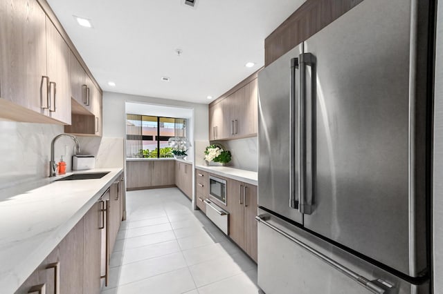 899 Jeffery St Unit 208, Boca Raton, FL 33487 - kitchen featuring stainless steel appliances, modern cabinets, backsplash, light tile patterned floors, and light stone counters