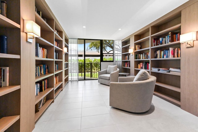 899 Jeffery St Unit 208, Boca Raton, FL 33487 - sitting room with bookshelves, tile patterned floors, floor to ceiling windows, and built in shelves