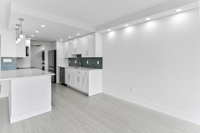 899 Jeffery St Unit 208, Boca Raton, FL 33487 - kitchen with stacked washing machine and dryer, recessed lighting, stainless steel appliances, light countertops, and white cabinets