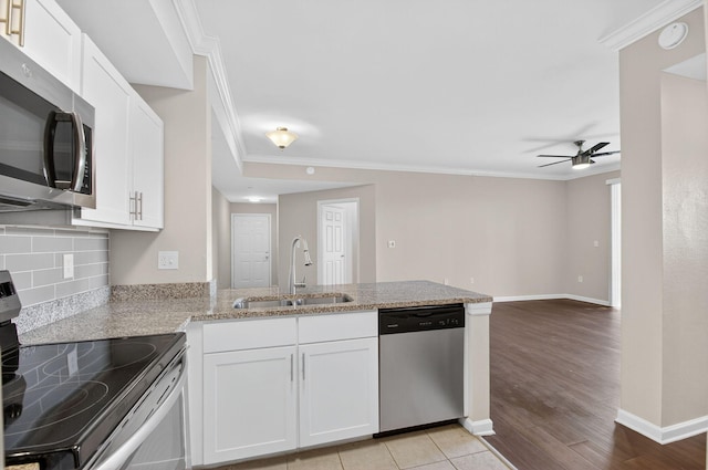 15045 Michelangelo Blvd Unit 104, Delray Beach, FL 33446 - kitchen featuring appliances with stainless steel finishes, ornamental molding, a ceiling fan, a peninsula, and decorative backsplash