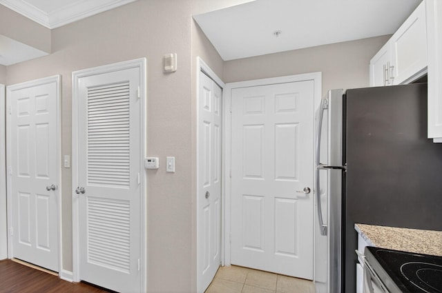 15045 Michelangelo Blvd Unit 104, Delray Beach, FL 33446 - kitchen with crown molding, white cabinetry, electric stove, light tile patterned floors, and freestanding refrigerator