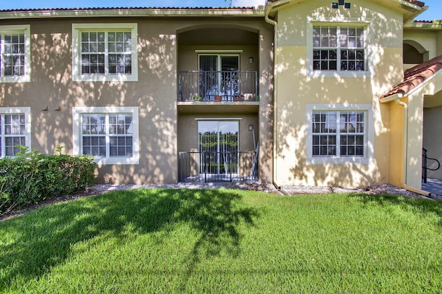 15045 Michelangelo Blvd Unit 104, Delray Beach, FL 33446 - rear view of house with a balcony, stucco siding, and a lawn