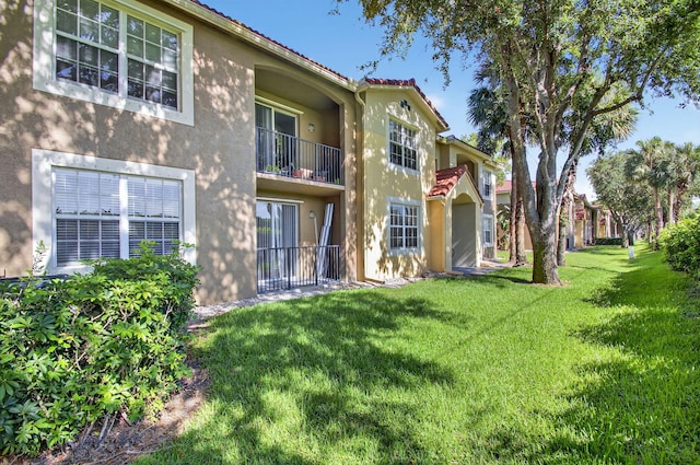 15045 Michelangelo Blvd Unit 104, Delray Beach, FL 33446 - back of property with stucco siding, a balcony, and a lawn