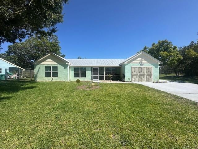 1910 SE Rainier Rd, Port Saint Lucie, FL 34952 - single story home featuring driveway, a garage, a front lawn, and a metal roof