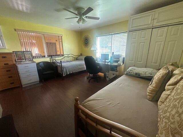 1910 SE Rainier Rd, Port Saint Lucie, FL 34952 - bedroom with dark wood-style floors, an office area, a ceiling fan, and a closet