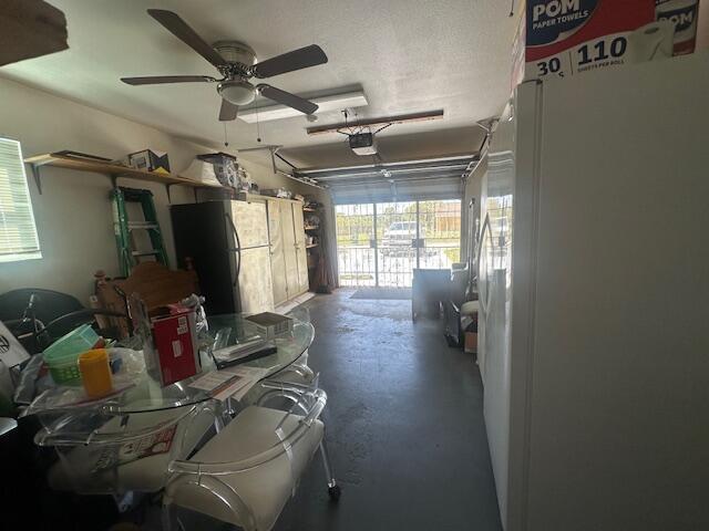 1910 SE Rainier Rd, Port Saint Lucie, FL 34952 - garage with a garage door opener and a ceiling fan