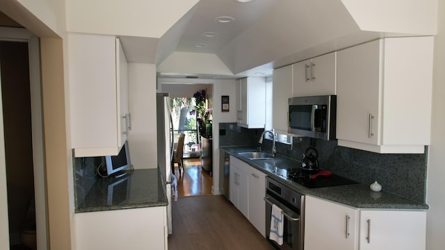 6864 Willow Wood Dr Unit 408, Boca Raton, FL 33434 - kitchen with appliances with stainless steel finishes, decorative backsplash, wood finished floors, white cabinetry, and dark stone countertops