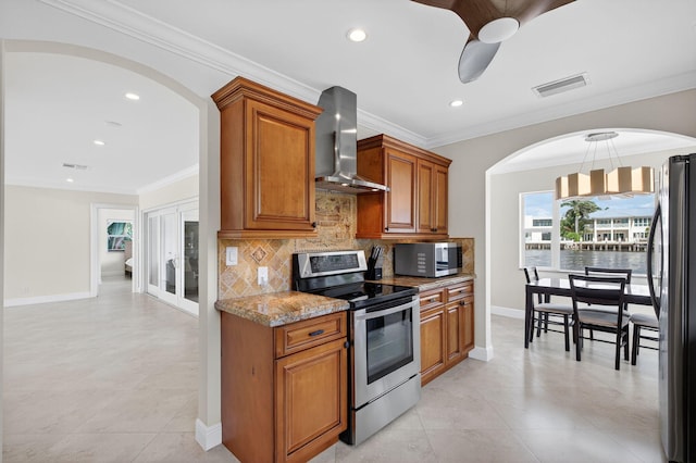 1921 W Terra Mar Dr, Lauderdale By The Sea, FL 33062 - kitchen with appliances with stainless steel finishes, wall chimney range hood, backsplash, brown cabinets, and arched walkways