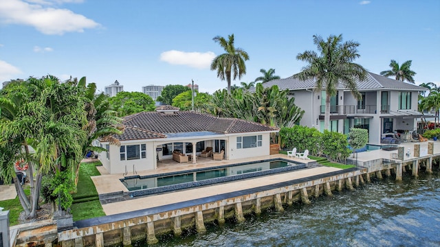 1921 W Terra Mar Dr, Lauderdale By The Sea, FL 33062 - back of property with a water view, a balcony, an outdoor pool, and a patio