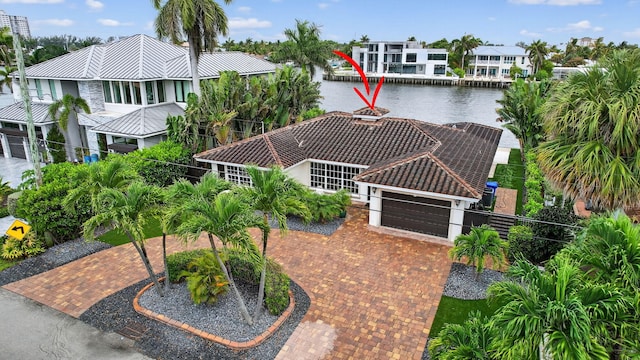 1921 W Terra Mar Dr, Lauderdale By The Sea, FL 33062 - view of front of house with an attached garage, a water view, decorative driveway, a residential view, and a tile roof