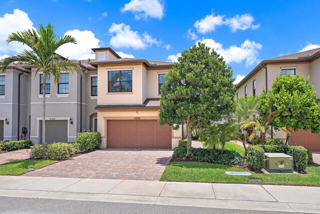 2366 Byron St, Palm Springs, FL 33406 - townhome / multi-family property with stucco siding, an attached garage, decorative driveway, and a tile roof