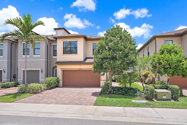 2366 Byron St, Palm Springs, FL 33406 - townhome / multi-family property with stucco siding, an attached garage, decorative driveway, and a tile roof