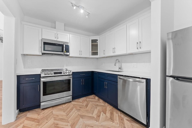 1420 Lake Ave, Lake Worth Beach, FL 33460 - kitchen featuring stainless steel appliances, blue cabinetry, white cabinets, and light countertops