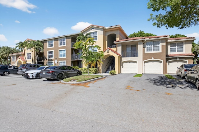15035 Michelangelo Blvd Unit 105, Delray Beach, FL 33446 - view of front of property with stucco siding, a tiled roof, a garage, and asphalt driveway