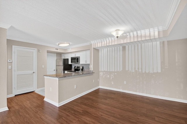 15035 Michelangelo Blvd Unit 105, Delray Beach, FL 33446 - kitchen featuring appliances with stainless steel finishes, crown molding, white cabinets, dark wood-style floors, and light stone countertops