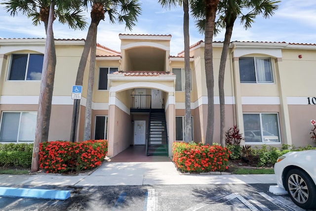 815 W Boynton Beach Blvd Unit 10-202, Boynton Beach, FL 33426 - view of building exterior featuring stairs and uncovered parking