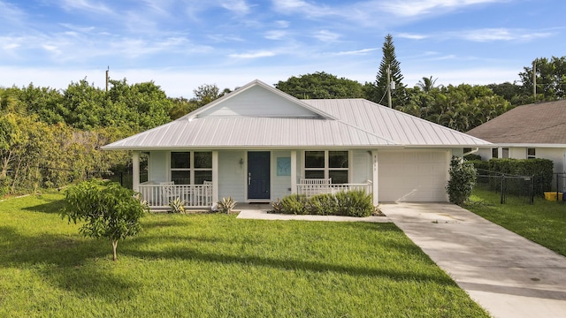9155 SE Athena St, Hobe Sound, FL 33455 - view of front of house featuring covered porch, a garage, driveway, and a metal roof