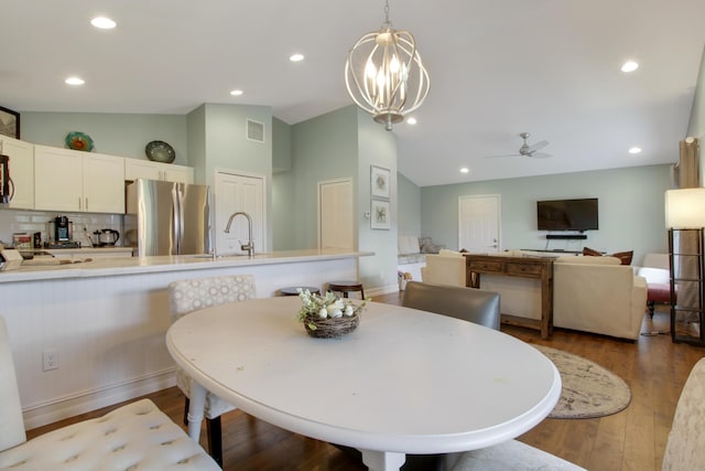 9155 SE Athena St, Hobe Sound, FL 33455 - dining room featuring vaulted ceiling, wood finished floors, a ceiling fan, a chandelier, and recessed lighting
