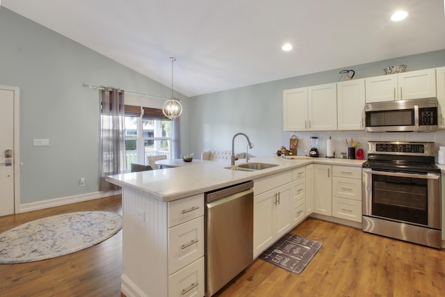 9155 SE Athena St, Hobe Sound, FL 33455 - kitchen with appliances with stainless steel finishes, lofted ceiling, light countertops, a peninsula, and white cabinets