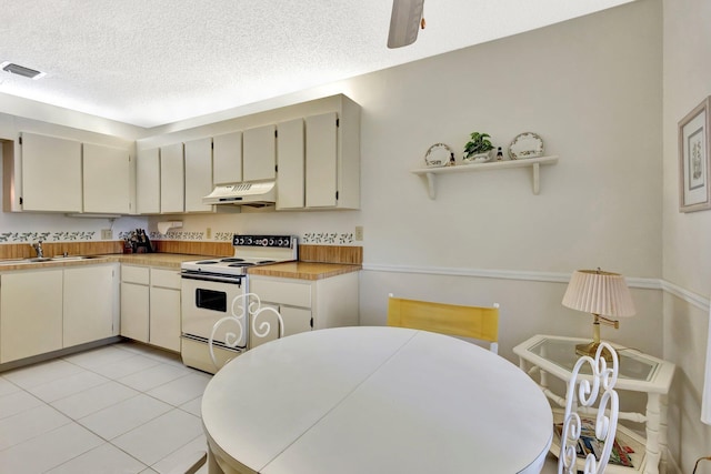 1600 SE Saint Lucie Blvd SE Unit 211, Stuart, FL 34996 - kitchen featuring electric range, under cabinet range hood, a textured ceiling, light countertops, and light tile patterned flooring