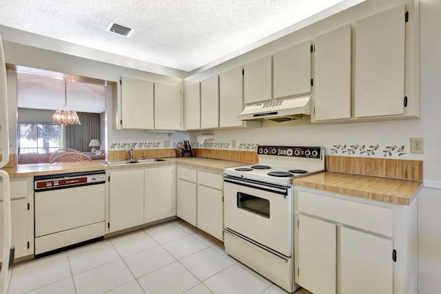 1600 SE Saint Lucie Blvd SE Unit 211, Stuart, FL 34996 - kitchen featuring white appliances, range hood, a chandelier, light countertops, and a textured ceiling