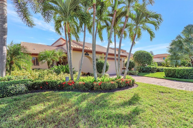 13308 Verdun Dr, Palm Beach Gardens, FL 33410 - view of home's exterior with a tile roof, decorative driveway, stucco siding, a lawn, and a garage