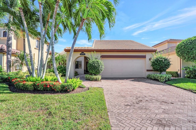 13308 Verdun Dr, Palm Beach Gardens, FL 33410 - mediterranean / spanish-style home with a tiled roof, stucco siding, an attached garage, decorative driveway, and a front yard