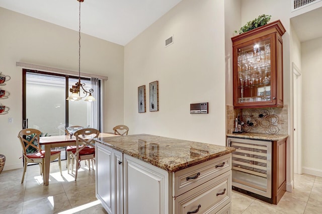 13308 Verdun Dr, Palm Beach Gardens, FL 33410 - kitchen with beverage cooler, a chandelier, light stone countertops, tasteful backsplash, and pendant lighting