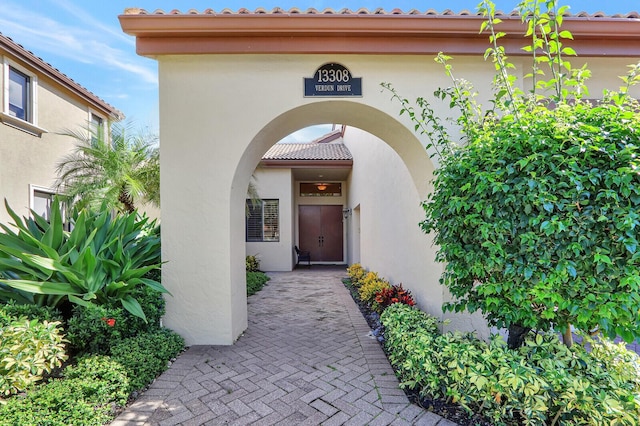 13308 Verdun Dr, Palm Beach Gardens, FL 33410 - property entrance featuring a tile roof and stucco siding