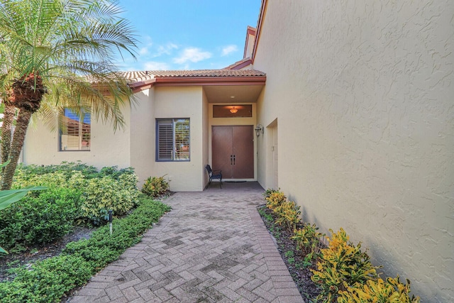 13308 Verdun Dr, Palm Beach Gardens, FL 33410 - view of exterior entry with stucco siding and a tiled roof
