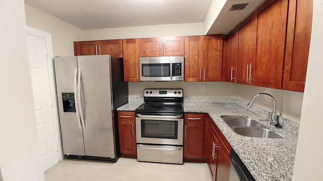3710 NW 21st St Unit 214, Lauderdale Lakes, FL 33311 - kitchen featuring stainless steel appliances, light stone countertops, light tile patterned floors, and brown cabinets
