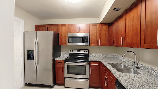 3710 NW 21st St Unit 214, Lauderdale Lakes, FL 33311 - kitchen with stainless steel appliances, light stone countertops, and brown cabinetry