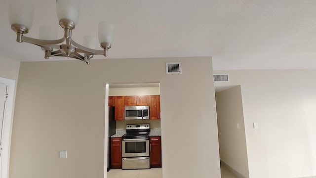 3710 NW 21st St Unit 214, Lauderdale Lakes, FL 33311 - kitchen featuring appliances with stainless steel finishes, a chandelier, and light countertops