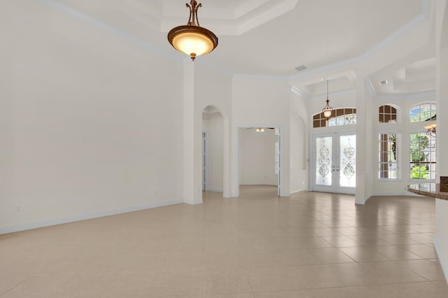 8732 Bally Bunion Rd, Port Saint Lucie, FL 34986 - unfurnished living room with french doors, arched walkways, a towering ceiling, light tile patterned flooring, and ornamental molding