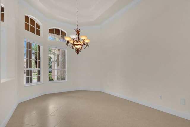 8732 Bally Bunion Rd, Port Saint Lucie, FL 34986 - spare room featuring healthy amount of natural light, a chandelier, light tile patterned floors, and a tray ceiling