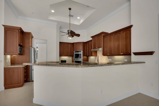 8732 Bally Bunion Rd, Port Saint Lucie, FL 34986 - kitchen featuring stainless steel appliances, dark stone countertops, tasteful backsplash, a peninsula, and a ceiling fan