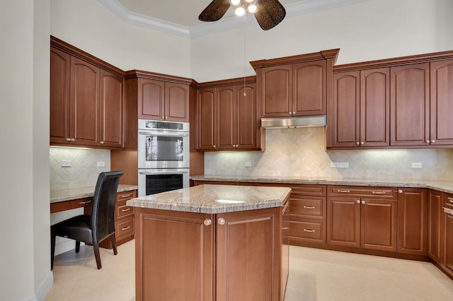 8732 Bally Bunion Rd, Port Saint Lucie, FL 34986 - kitchen with double oven, under cabinet range hood, ceiling fan, a center island, and decorative backsplash