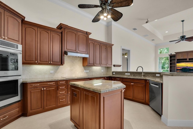 8732 Bally Bunion Rd, Port Saint Lucie, FL 34986 - kitchen featuring stainless steel appliances, a ceiling fan, ornamental molding, backsplash, and a peninsula